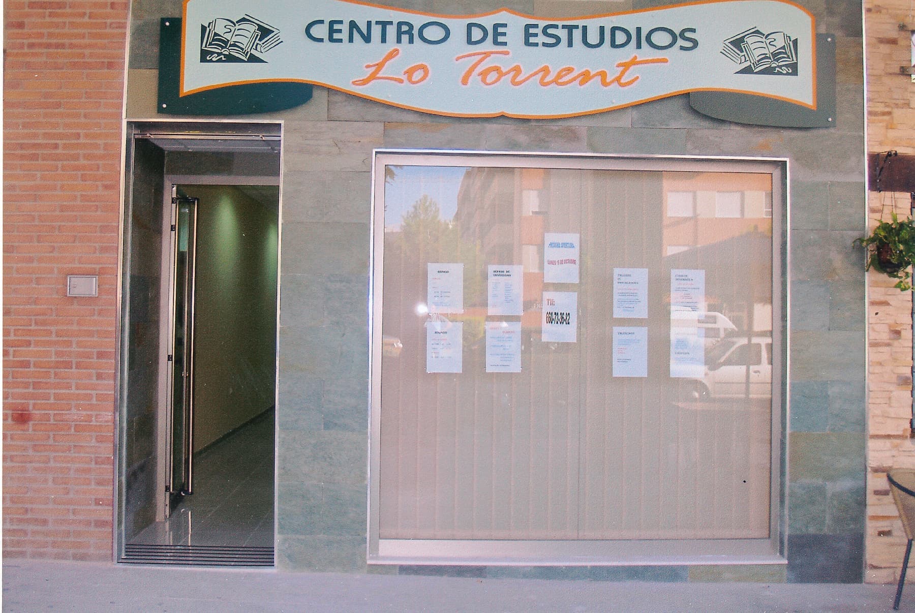 Rótulo de madera del Centro de Estudios Lo Torrent sobre la entrada